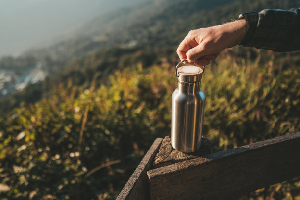 一名男子手持热水瓶站在观察点图片下载