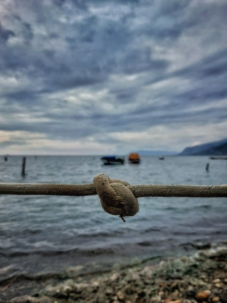 绳索结与近岸的船只在背景图片下载