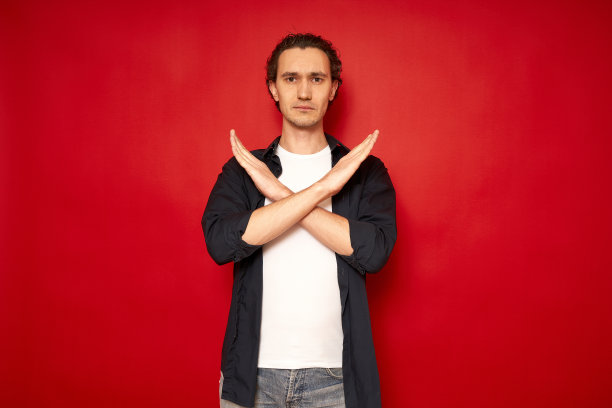 严重的消极的人不高兴的悲伤的交叉的手显示没有停止下降拒绝标志孤立的红色背景与自由的空间的文字。概念抗议，分歧，阻拦，暂停，游戏结束图片下载