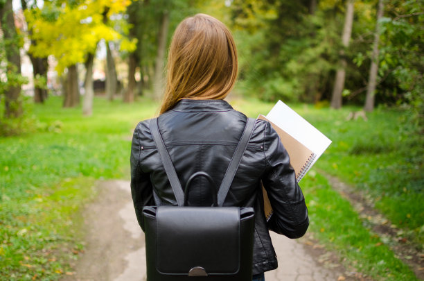 十几岁的女孩在户外拿着书图片下载