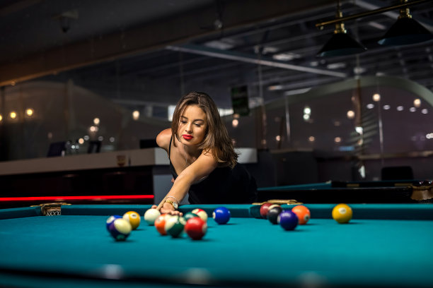 一个欢快的年轻女子在酒吧里打台球图片下载