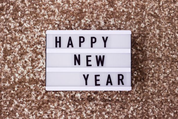 灯板以金色亮片为背景，上面刻着新年字样。寒假图片下载