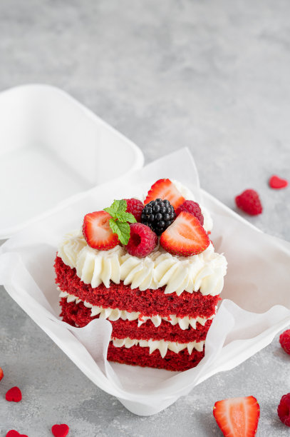 红丝绒便当蛋糕。灰色混凝土背景下的午餐盒里的一块小蛋糕。情人节蛋糕。亚洲食品的趋势。适合任何节日的可爱礼物。副本的空间。图片下载
