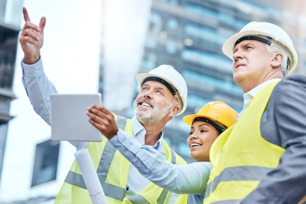 一群商务人士在建筑工地工作时使用电子平板电脑图片下载