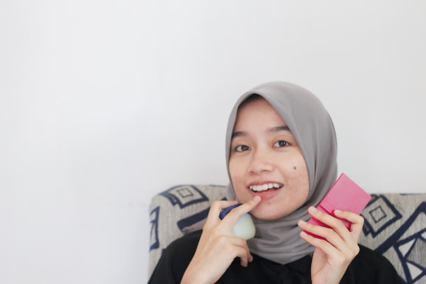 年轻女性在家里使用唇部护理图片下载