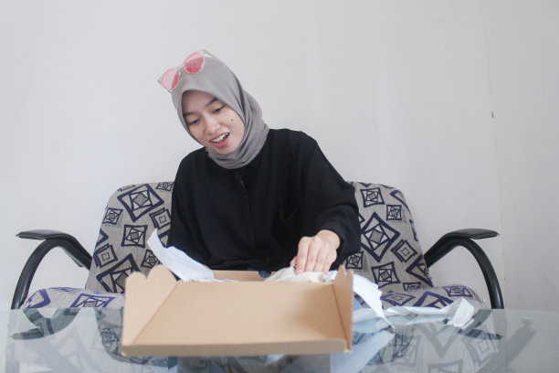 亚洲妇女高兴地打开礼盒图片下载