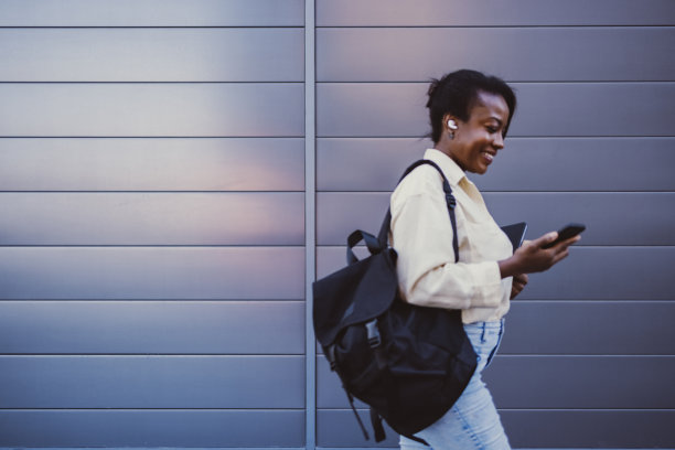 快乐的女商人在户外使用手机图片下载