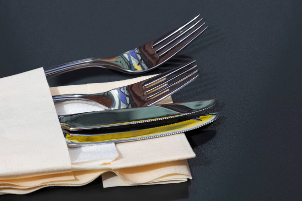 刀叉放在布上，餐巾放在黑色的桌子上，上菜图片下载