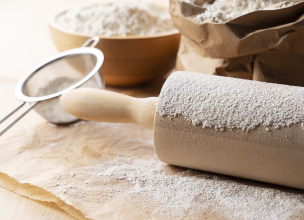 桌上放着面粉和擀面杖。制作面包的概念照片。图片下载
