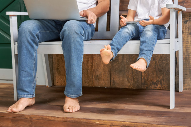 爷爷和孙子拿着小玩意坐在木屋附近的长凳上图片下载