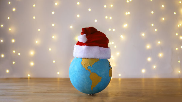 地球星球戴着圣诞帽，站在满是彩灯的节日背景前。美洲版本(见我的个人资料中的其他版本)图片下载