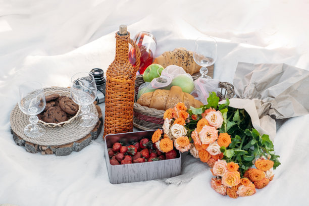 夏季野餐食品，户外午餐在公园。野餐在夏天草莓，水果，羊角面包，饼干，葡萄酒，果汁在毯子背景俯视图。浪漫的草地野餐，美味的食物图片下载