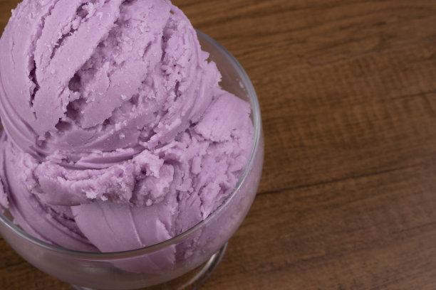 葡萄味的紫色冰淇淋，装在玻璃碗里。上面的照片与自由空间在右边。图片下载