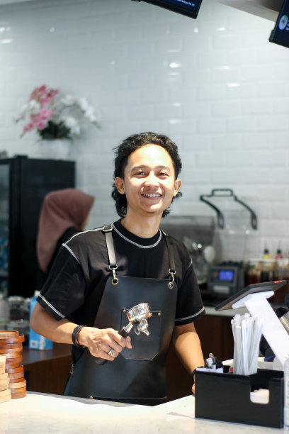 年轻的咖啡师在煮咖啡图片下载