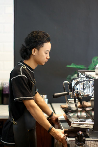 年轻的咖啡师在煮咖啡图片下载