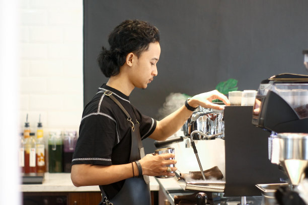 年轻的咖啡师在煮咖啡图片下载
