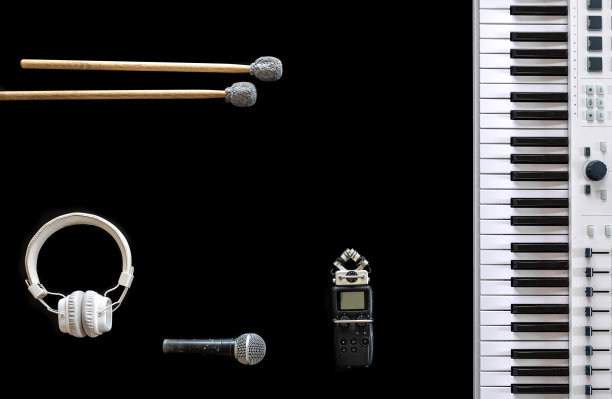 音乐键、耳机、录音机和麦克风放在黑色背景上，平放。图片下载