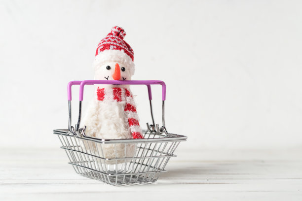 白色背景上的玩具雪人和购物篮。圣诞节、新年销售理念。图片下载
