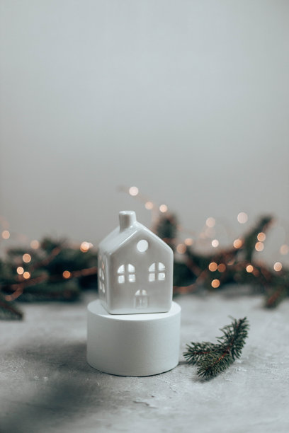 白色舒适的家庭模型在灰色的背景。圣诞节和新年的主题。圣诞节和新年假期背景。常绿云杉树枝框架在灰色的混凝土背景图片下载