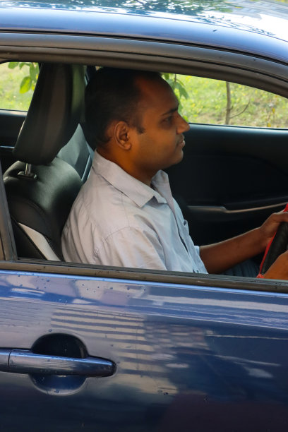 印度男子驾驶私人出租车在路上不系安全带，危险的驾驶概念图片下载