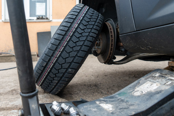 照片中的汽车车轮从汽车上取下来安装轮胎。图片下载