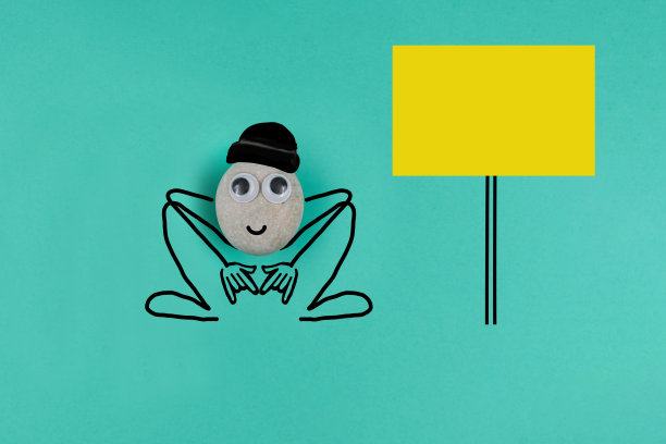 动画卵石在黑色羊毛帽蹲下来，与大备忘录在蓝色的纸背景图片下载