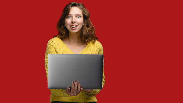 红色背景上的女人像，使用笔记本电脑在线工作的人。与现代观念的人，时尚女孩穿着黄色毛衣和工作自由。有复印空间的女人图片下载