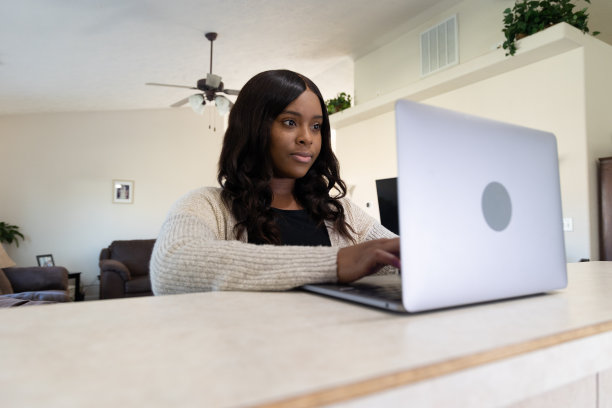 漂亮的年轻女人在笔记本电脑上打字，在家照顾生意图片下载