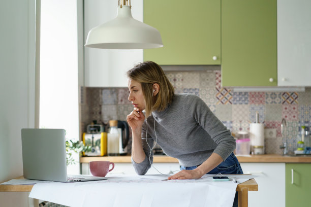 专注于女性设计师或建筑师的工作，在家检查建筑蓝图与在线文件图片下载