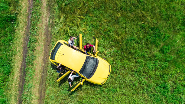 家人和朋友开车度假，快乐的父母和孩子在假期旅行的乐趣，无人机从上面看汽车和人图片下载
