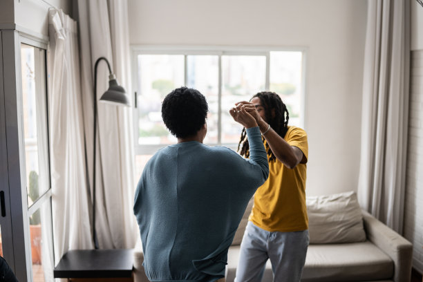 母亲和儿子在家里的客厅里跳舞图片下载