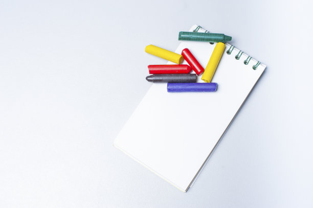 笔记本和木制彩色笔隔离在白色背景上。本空间图片下载