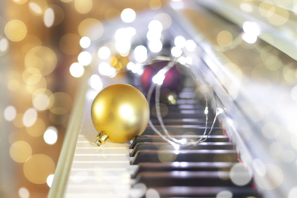 圣诞金球与花环在钢琴上在散景背景。新年或圣诞音乐概念图片下载