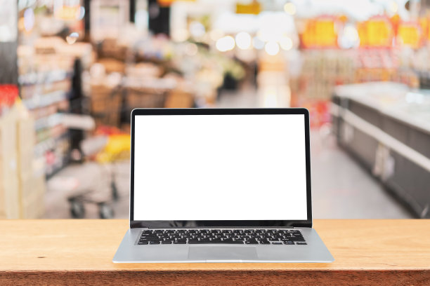 空屏幕笔记本电脑在木桌与抽象模糊的形象超市商店在商场图片下载