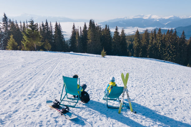 滑雪者和单板滑雪者坐在山顶的椅子上享受图片下载
