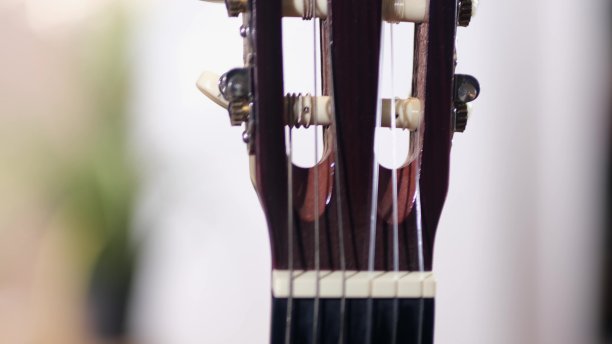 在原声吉他的琴颈上，有弦和琴弦。近距离图片下载