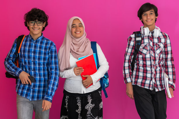 一群阿拉伯青少年，一个学生团队走向未来，回到学校的粉色背景的概念。成功教育的概念为年轻人。有选择性的重点图片下载