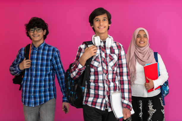 一群阿拉伯青少年，一个学生团队走向未来，回到学校的粉色背景的概念。成功教育的概念为年轻人。有选择性的重点图片下载