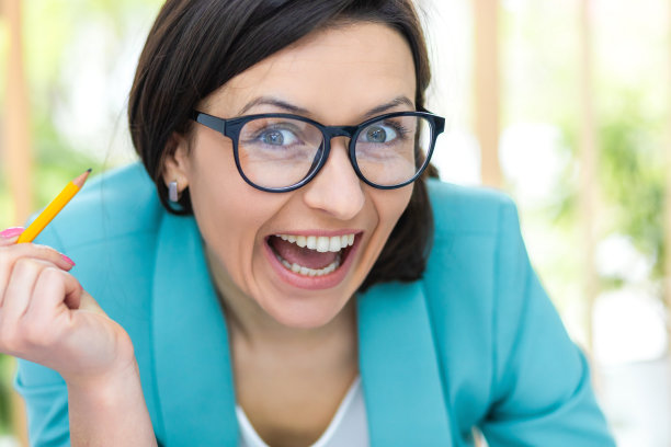 特写照片的妇女与铅笔戴黑眼镜。图片下载