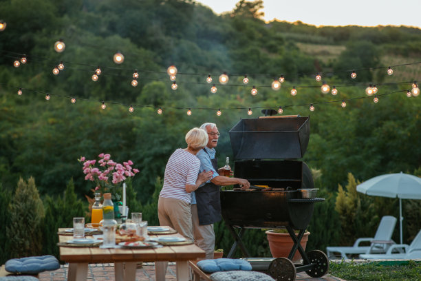 一位年长的女士给在后院烧烤的丈夫开了一家公司图片下载