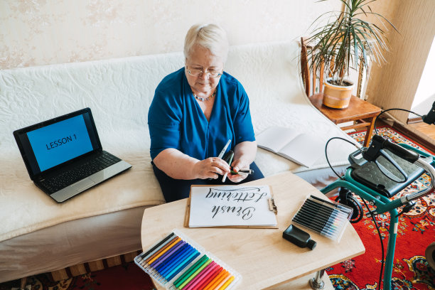 对老年人的爱好。退休爱好，老年人的消遣。为行动不便的长者准备的活动。成熟，年长的资深女画家绘画绘画，实践手写写字图片下载