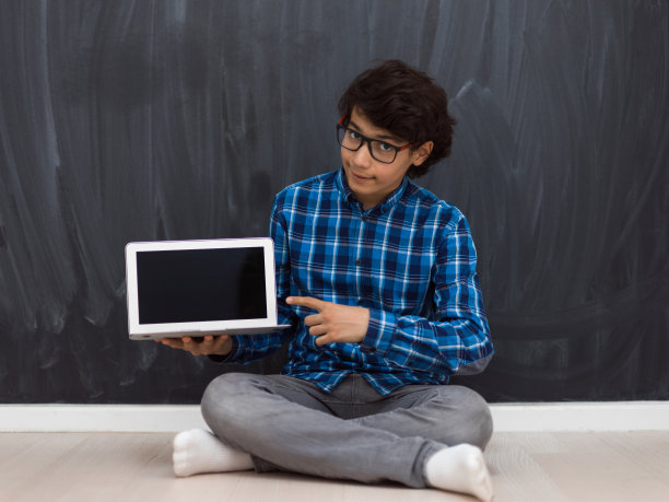 一名阿拉伯少年在家用笔记本电脑做作业、看在线教育，引起了新冠疫情的隔离图片下载