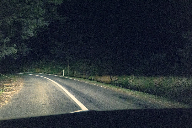在澳大利亚的一条黑暗的道路上行驶。图片下载