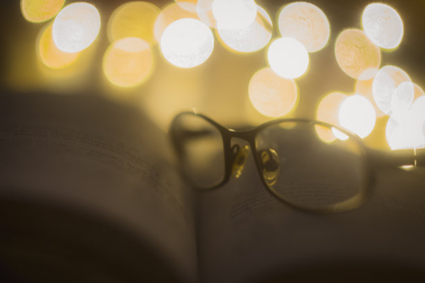 一副老花镜放在打开的书上图片下载