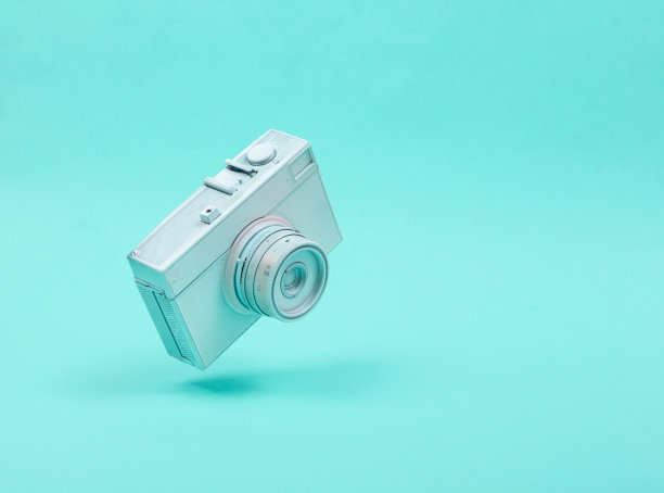 漂浮在蓝色背景上的白色相机。3 d照片。简约的静物画。创造性的布局。概念艺术图片下载