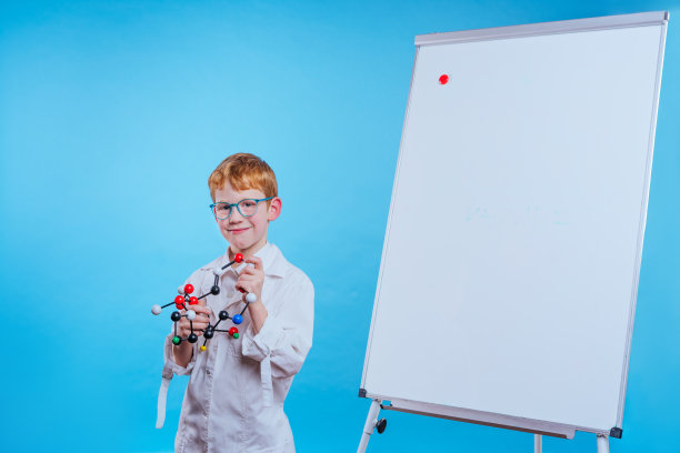 一名戴眼镜、身穿医袍、手持水晶格子模型的男生图片下载