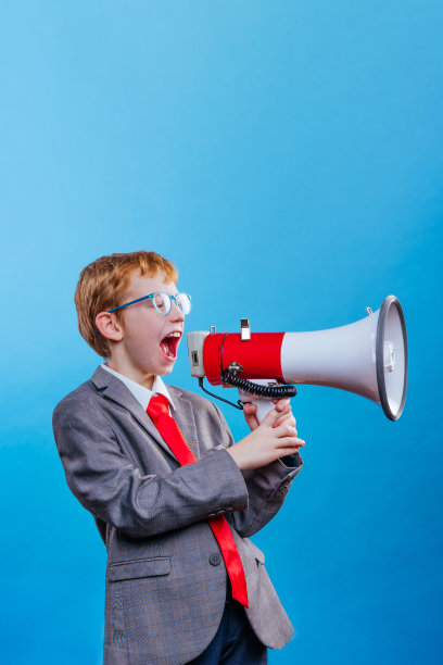 有趣的红头发男孩年轻的商人与眼镜在蓝色的背景图片下载