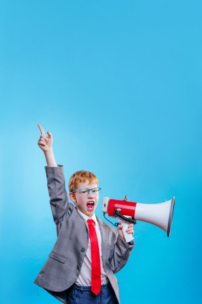 有趣的红头发男孩年轻的商人与眼镜在蓝色的背景图片下载