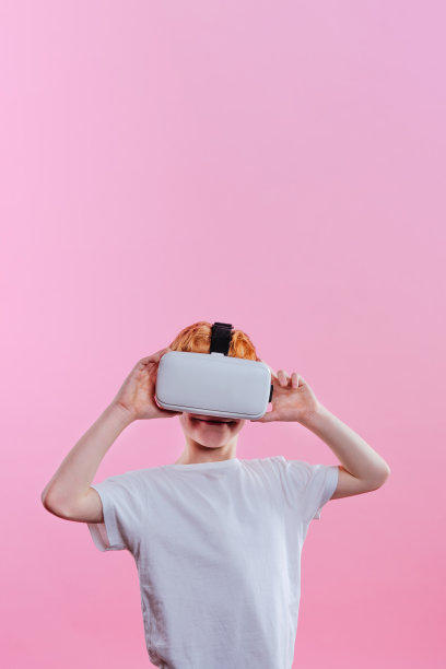 粉红色背景上穿着虚拟现实设备的男生图片下载