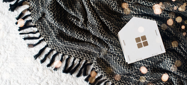 白色的玩具房子和礼物盒在黑色的毯子上图片下载